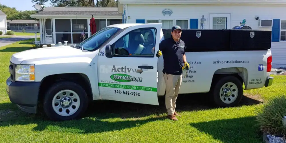 Tech standing next to Activ Pest Solutions truck