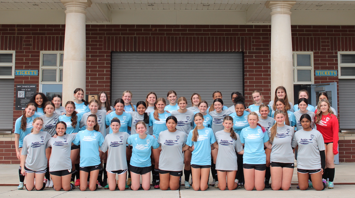 the lewes de high school girls soccer team posing in activ pest control sponsor shirts